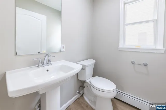 a bathroom with a sink a toilet and a mirror