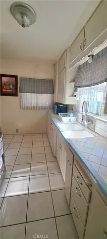 a kitchen with a sink a stove and cabinets