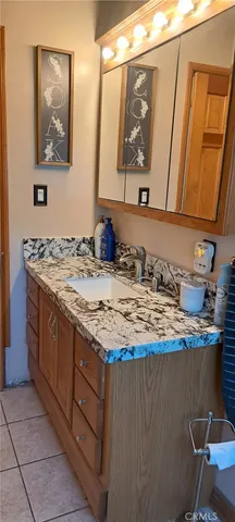 a bathroom with a granite countertop sink a mirror and vanity