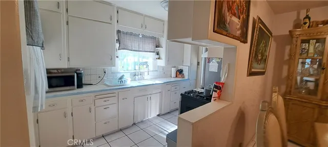 a kitchen with white cabinets and sink