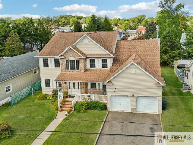 an aerial view of residential houses with outdoor space and trees