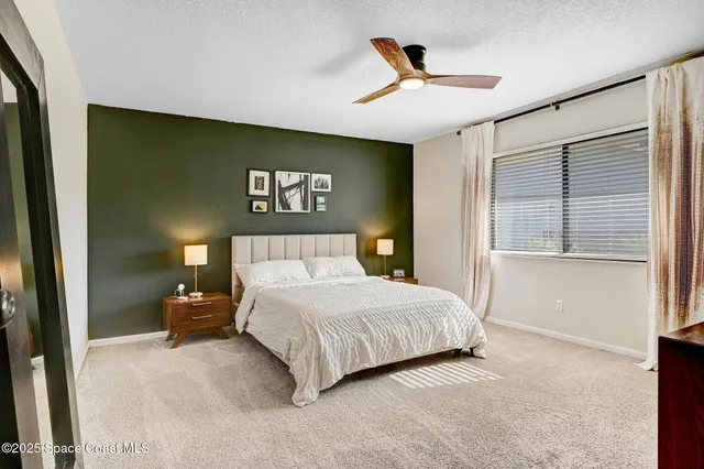 a bedroom with a large bed and a ceiling fan