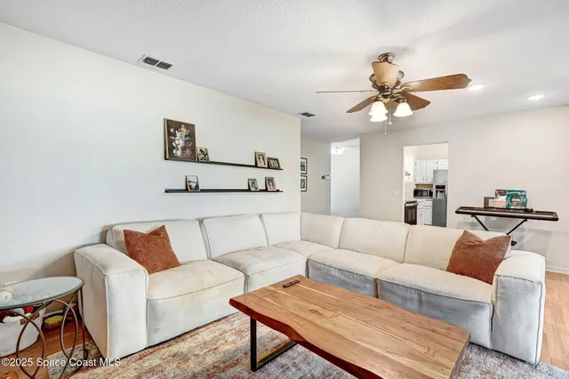 a living room with furniture a ceiling fan and a rug
