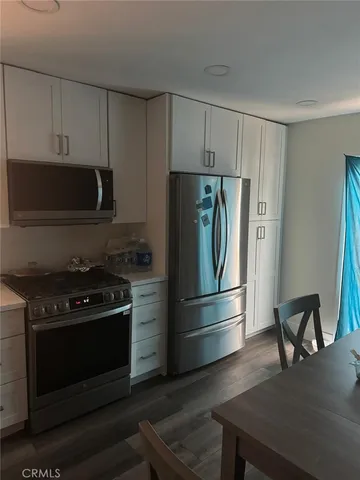 a kitchen with appliances a counter space and cabinets