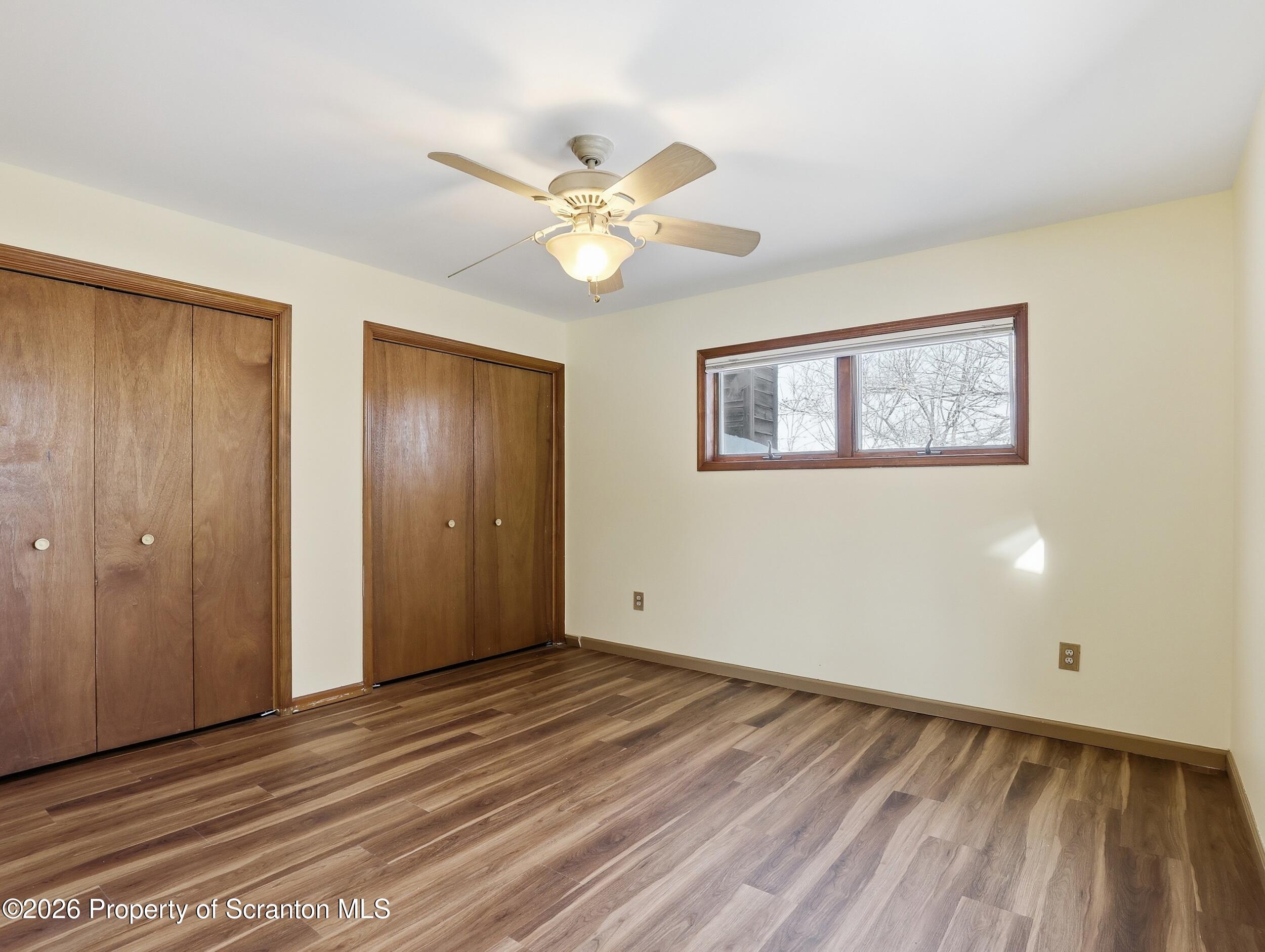 227 Image Drive Scotrun, PA 18355 - Photo 21 of 29 a view of an empty room with wooden floor and a ceiling fan