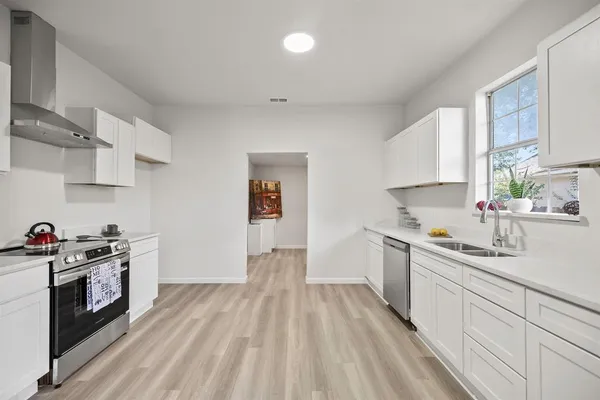 a kitchen with a sink a stove and cabinets