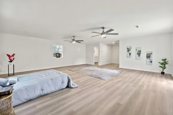 a spacious bedroom with a bed and a chandelier