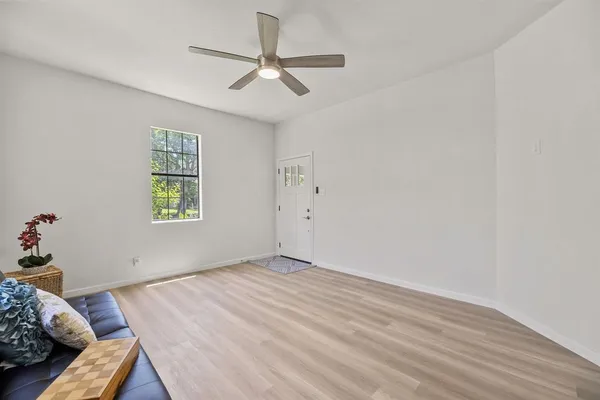 an empty room with a window and a fan