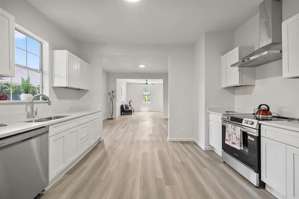 a kitchen with a sink a stove and cabinets