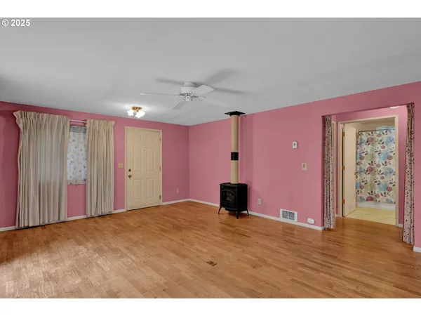 a view of an empty room with wooden floor