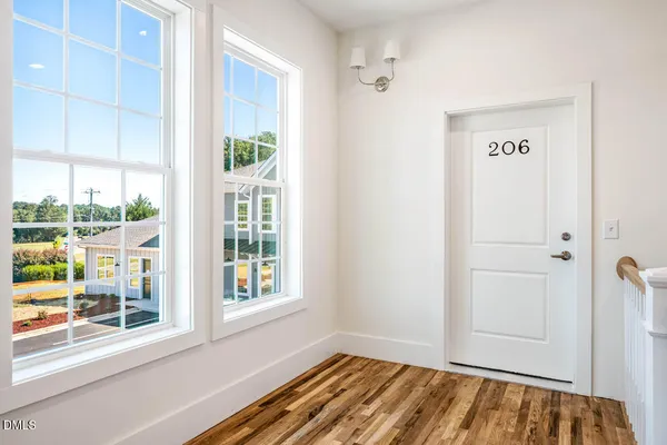 a view of an entryway with wooden floor and door