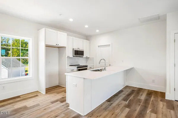 a kitchen with stainless steel appliances a sink stove and refrigerator