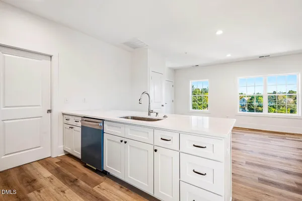 a kitchen with granite countertop white cabinets and white appliances