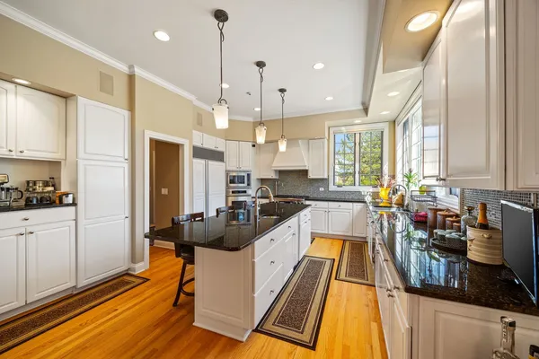 a large kitchen with kitchen island a large counter top space a sink stainless steel appliances and cabinets