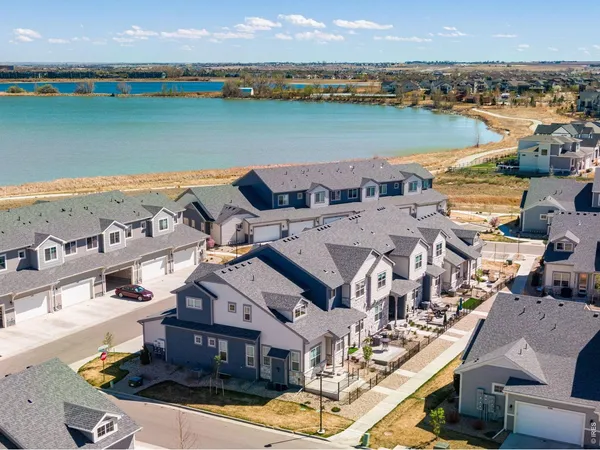 an aerial view of a house with outdoor space and lake view in back