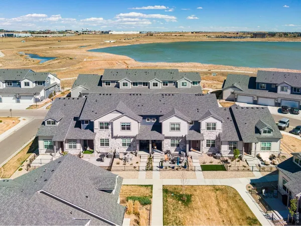 an aerial view of residential houses with outdoor space and ocean view