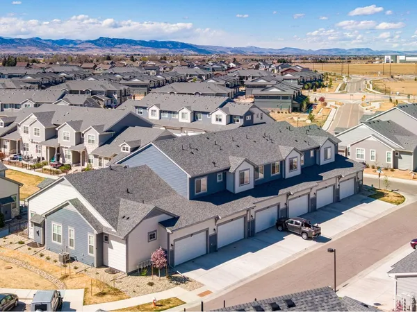 an aerial view of residential houses with outdoor space and ocean view