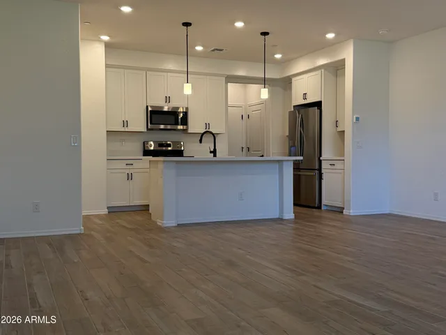 an empty room with wooden floor and window