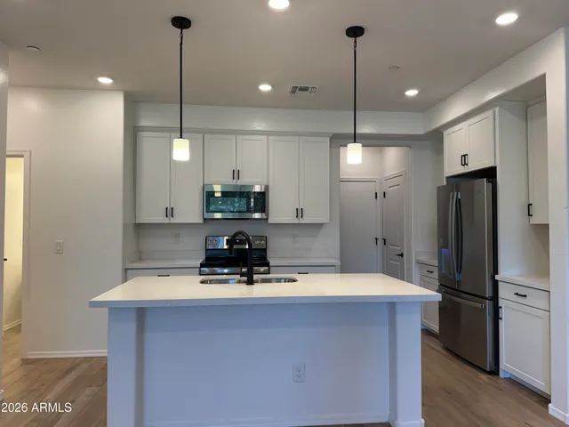 a kitchen with a sink a stove a refrigerator and a microwave