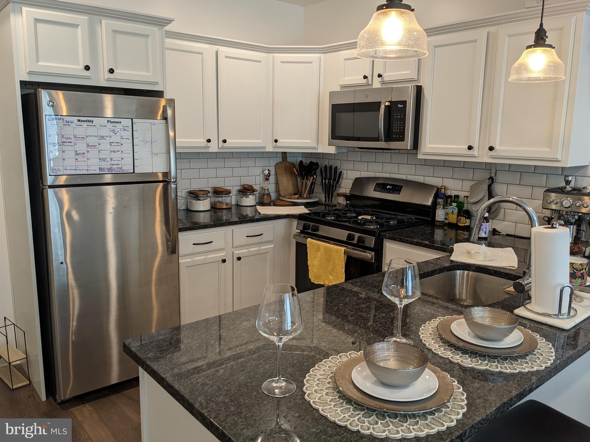 6615 Ridge Avenue, Unit 102 Philadelphia, PA 19128 - Photo 2 of 12 a kitchen with granite countertop a sink appliances and cabinets