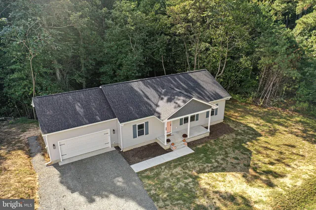 an aerial view of a house with yard and sitting area