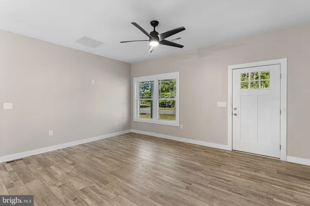 wooden floor in an empty room with a window