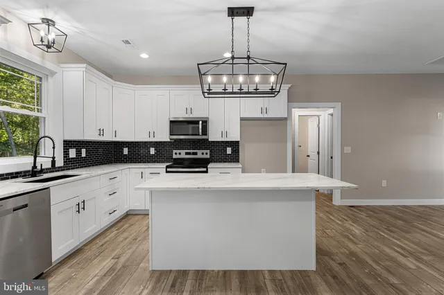 a kitchen with stainless steel appliances a stove refrigerator and cabinets