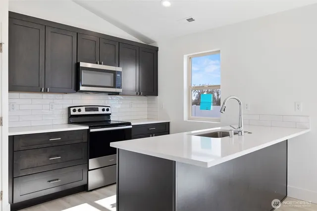 a kitchen with a sink a stove and microwave