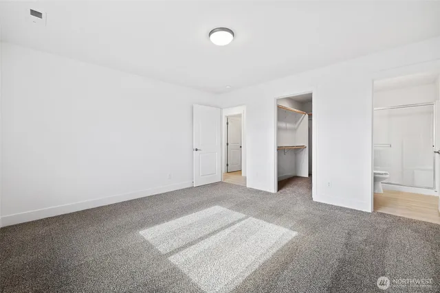 a view of an empty room with closet and entryway