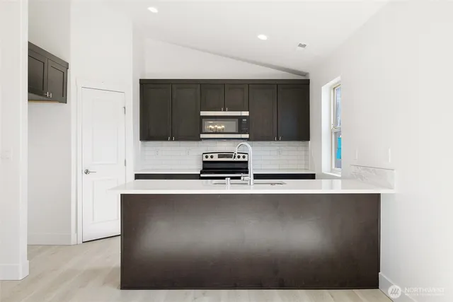 a kitchen with a sink a stove and a microwave