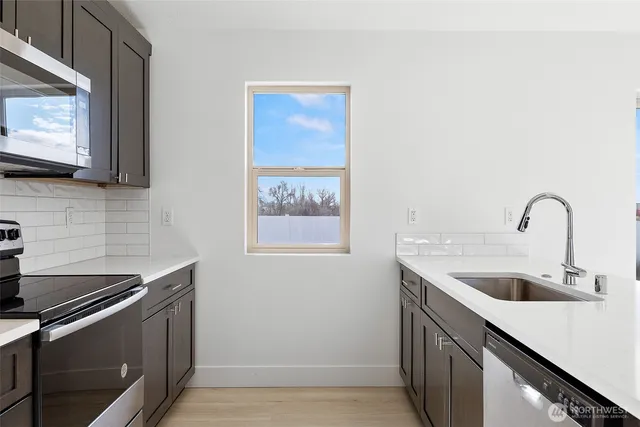 a kitchen with granite countertop a sink and a stove top oven