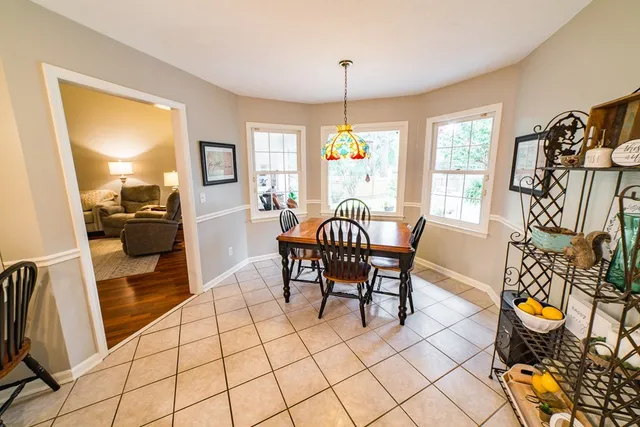 a dining room with furniture and a window