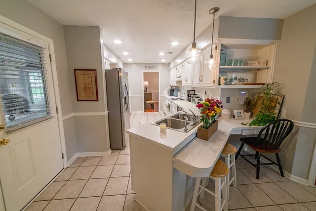 a living room with furniture a dining table and a refrigerator