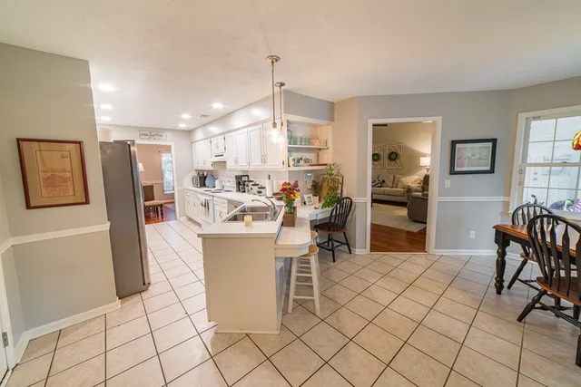 a kitchen with a sink white cabinets and white appliances