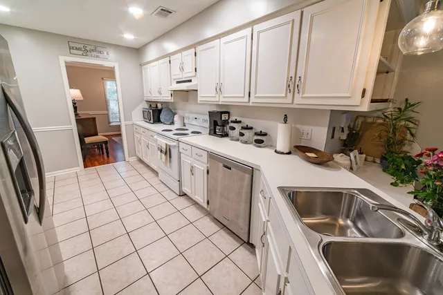 a kitchen with stainless steel appliances a white cabinets and a stove top oven