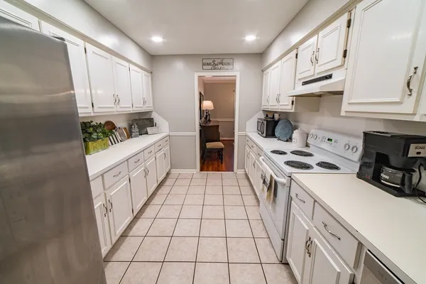 a kitchen with stainless steel appliances a sink a stove top oven a refrigerator and cabinets