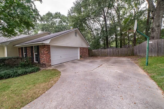 a view of a house with a yard and large tree