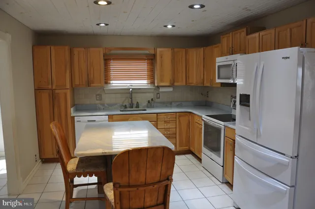 a backyard of a house with barbeque oven fire pit table and chairs