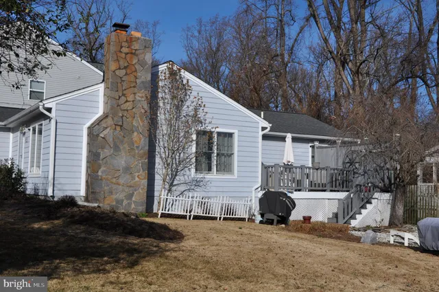 an empty room with wooden floor cabinet and windows
