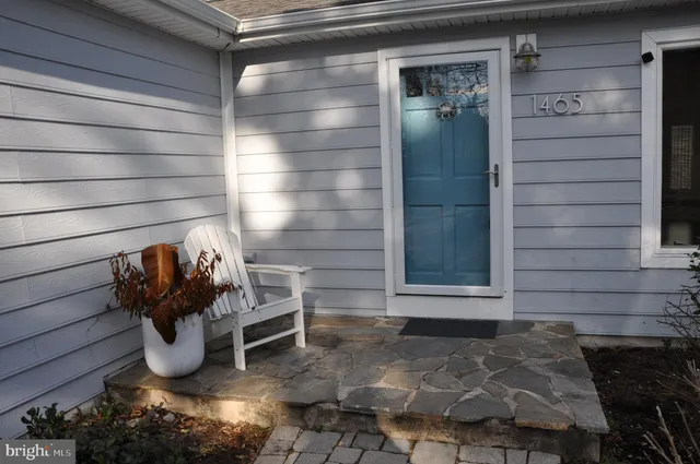 an empty room with wooden floor cabinet and windows