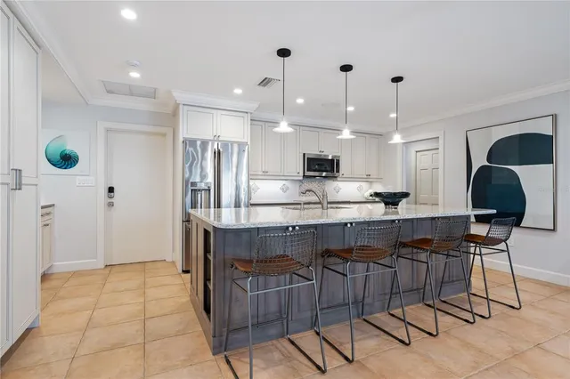 a kitchen with kitchen island granite countertop a table and chairs in it