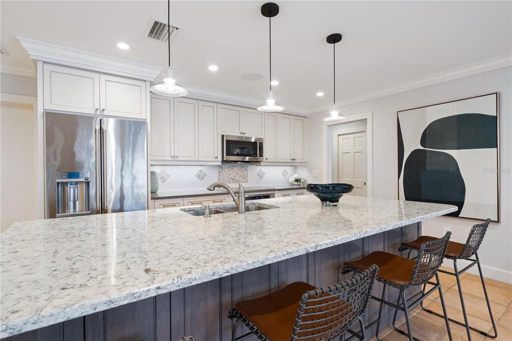 606 Owl Way Sarasota, FL 34236 - Photo 12 of 35 a large kitchen with granite countertop a counter space chairs stainless steel appliances and cabinets