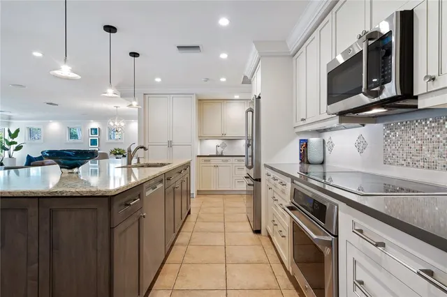 a kitchen with stainless steel appliances granite countertop a sink a stove and a microwave