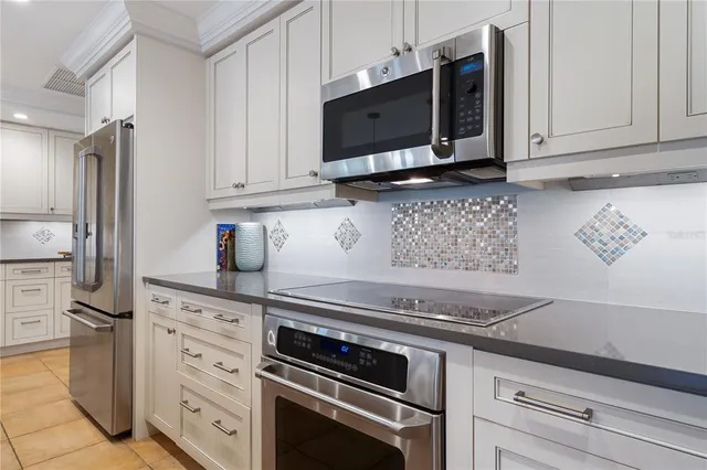 a kitchen with stainless steel appliances granite countertop a stove microwave and cabinets