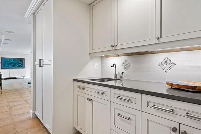 a kitchen with white cabinets and a wooden floor