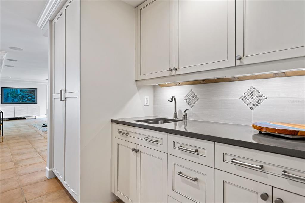 606 Owl Way Sarasota, FL 34236 - Photo 15 of 35 a kitchen with white cabinets and a wooden floor