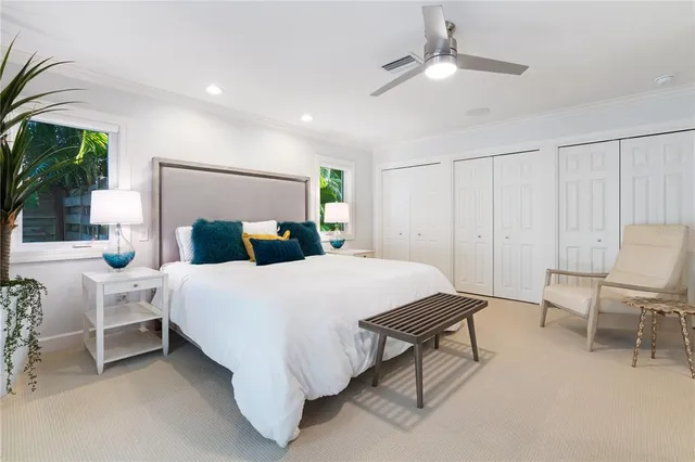 a bedroom with a bed a chair and potted plant on the table