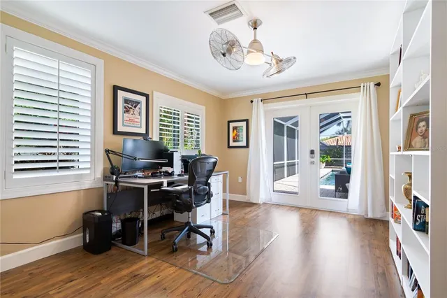 a view of a workspace with wooden floor and a window