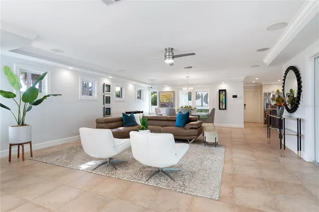 a living room with patio furniture and a potted plant