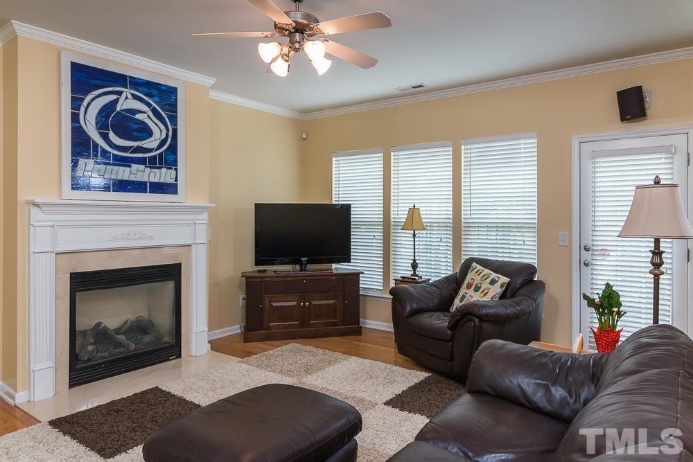 8437 Aztec Dawn Court Raleigh, NC 27613 - Photo 3 of 24 a living room with furniture a flat screen tv and a fireplace